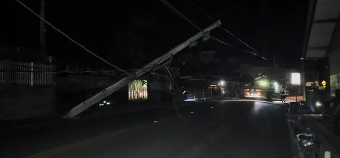 Poste cai sobre carro com casal em rua de Blumenau